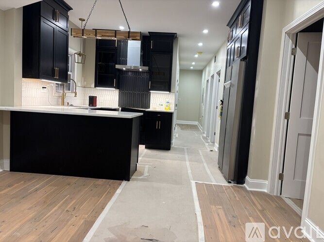 A kitchen with black cabinets and a wooden island.