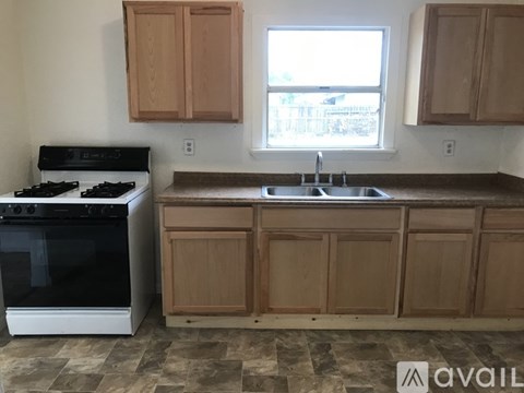 A kitchen with a black stove and wooden cabinets.