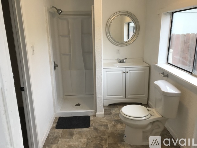 A bathroom with a toilet, sink, and shower.