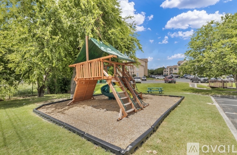 A playground with a green roofed structure and a slide.