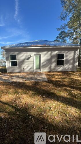 A small house with a metal roof is for sale.