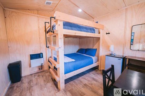 A bedroom with a bunk bed and a small table.