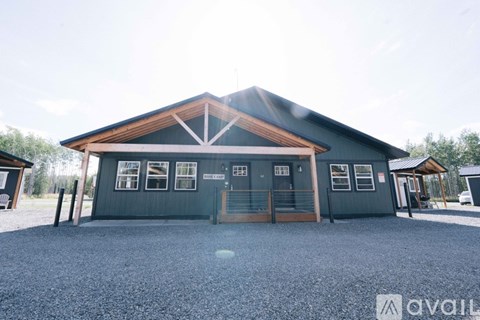 A large building with a gravel driveway in front.