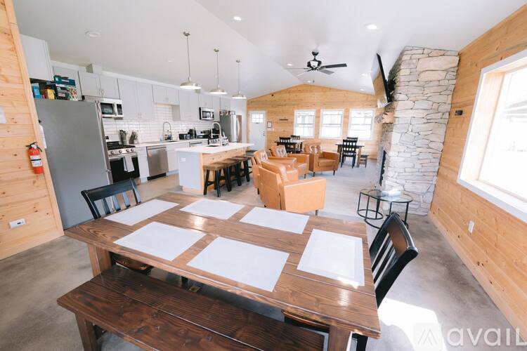 A kitchen with a table and chairs in the foreground and a stone wall in the background.