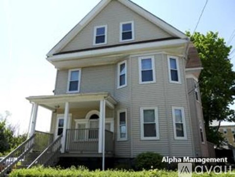 A two-story house with a balcony on the second floor.