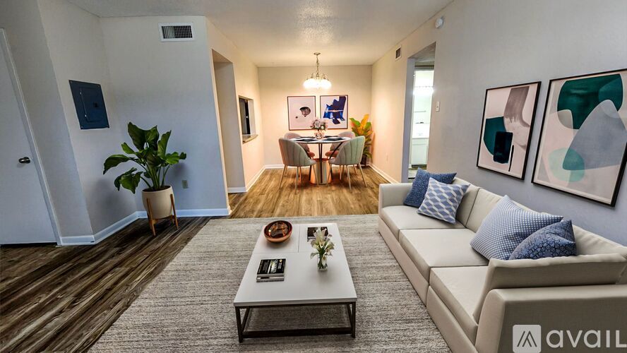 A living room with a couch, coffee table, and a plant.
