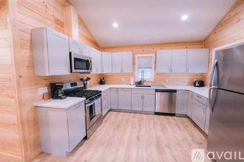 A kitchen with wooden walls and white appliances.