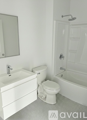 A white bathroom with a toilet, sink, and bathtub.