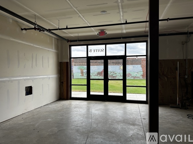 A room with a large window and a view of a grassy area outside.