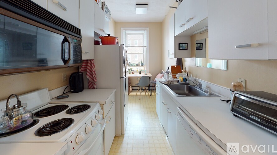 A kitchen with white appliances and a white stove top oven.