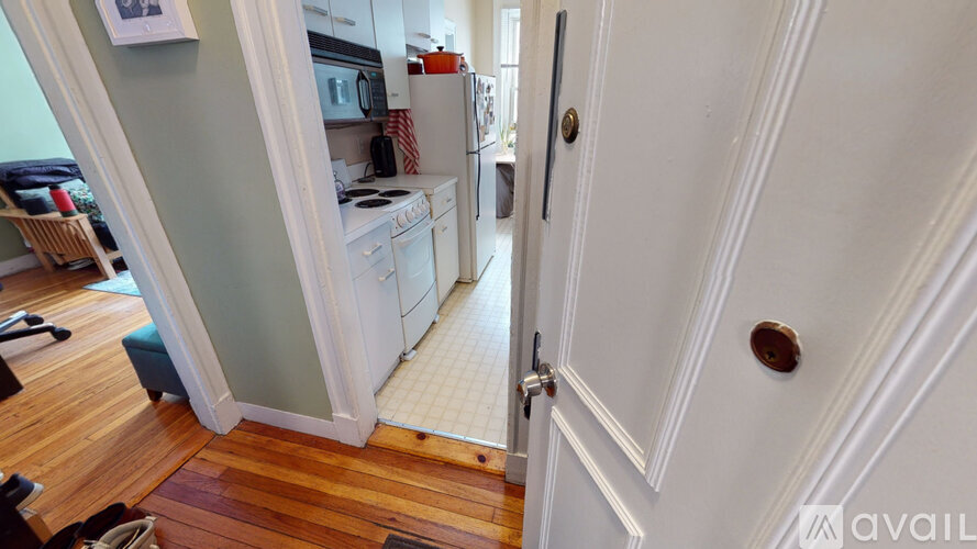 A kitchen with a white refrigerator and a white door.