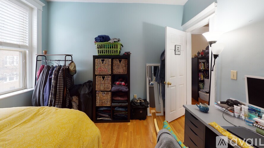 A bedroom with a bed, a closet, and a desk.