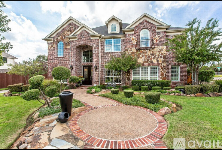 A house with a red brick exterior and a circular driveway.