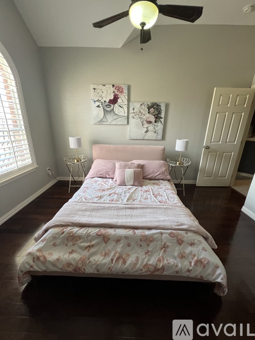 A bedroom with a large bed and a ceiling fan.
