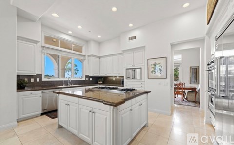 A modern kitchen with white cabinets and a large island.