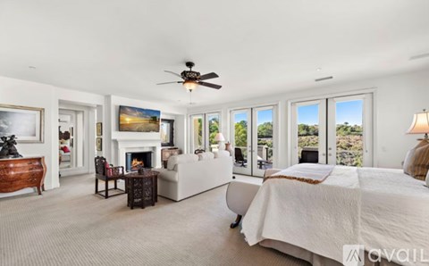 A bedroom with a large bed and a fireplace.