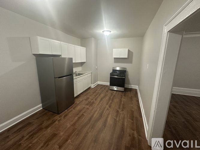 A kitchen area with a refrigerator, cabinets, and a dishwasher.