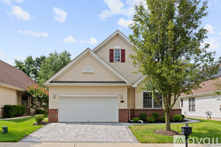 A house with a garage and a tree in front.