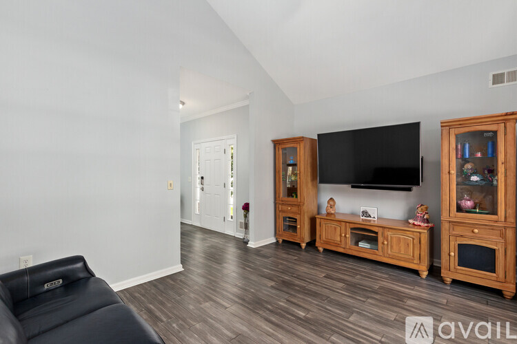 A living room with a black leather chair and wooden entertainment center.