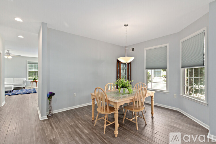 A dining room with a wooden table and chairs.