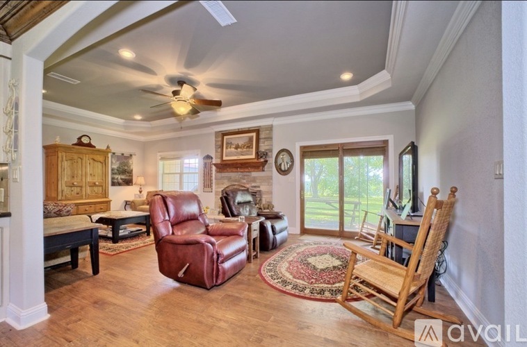 A living room with a red leather chair and a wooden rocking chair.