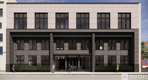 A modern building with a large glass entrance and a row of windows on the ground floor.