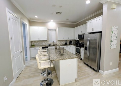 A kitchen with white cabinets and a granite countertop.