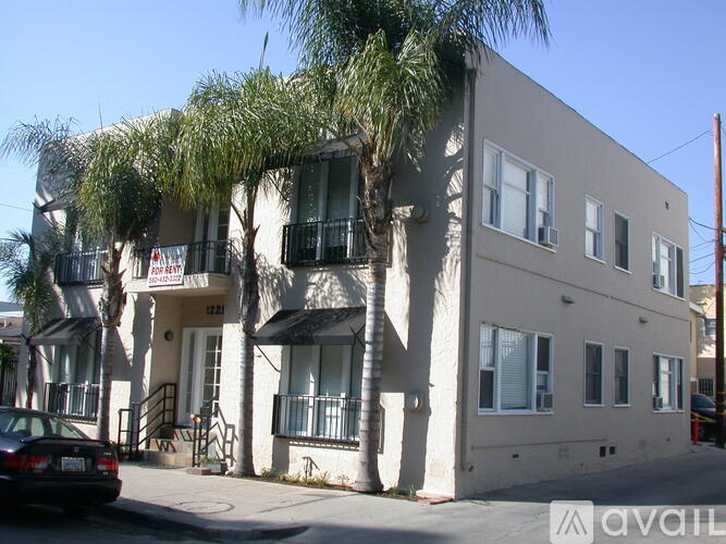 A building with a balcony and a tree in front of it.
