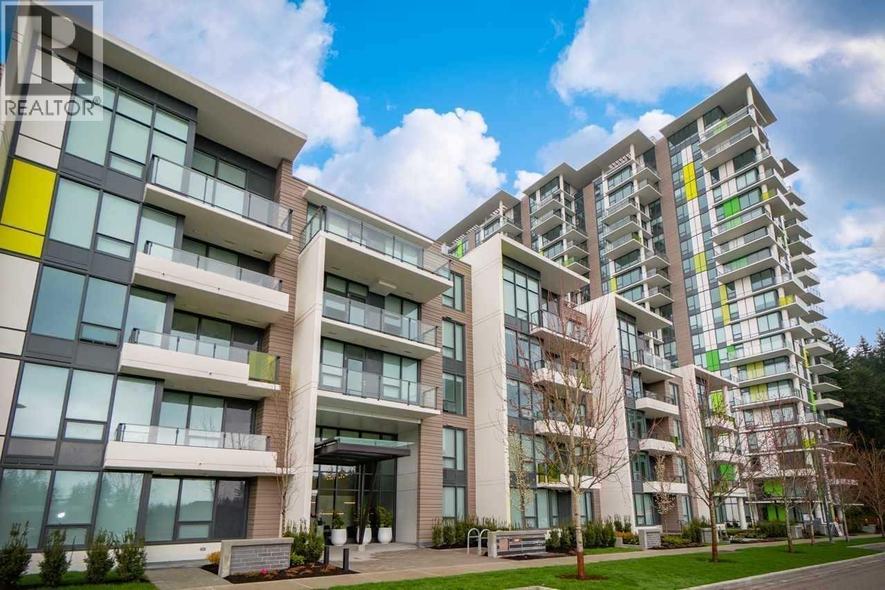 A modern apartment building with a glass entrance and balconies.