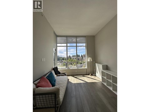 A living room with a couch and a large window.