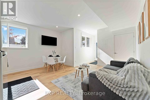 A living room with a grey couch and a white dining table.