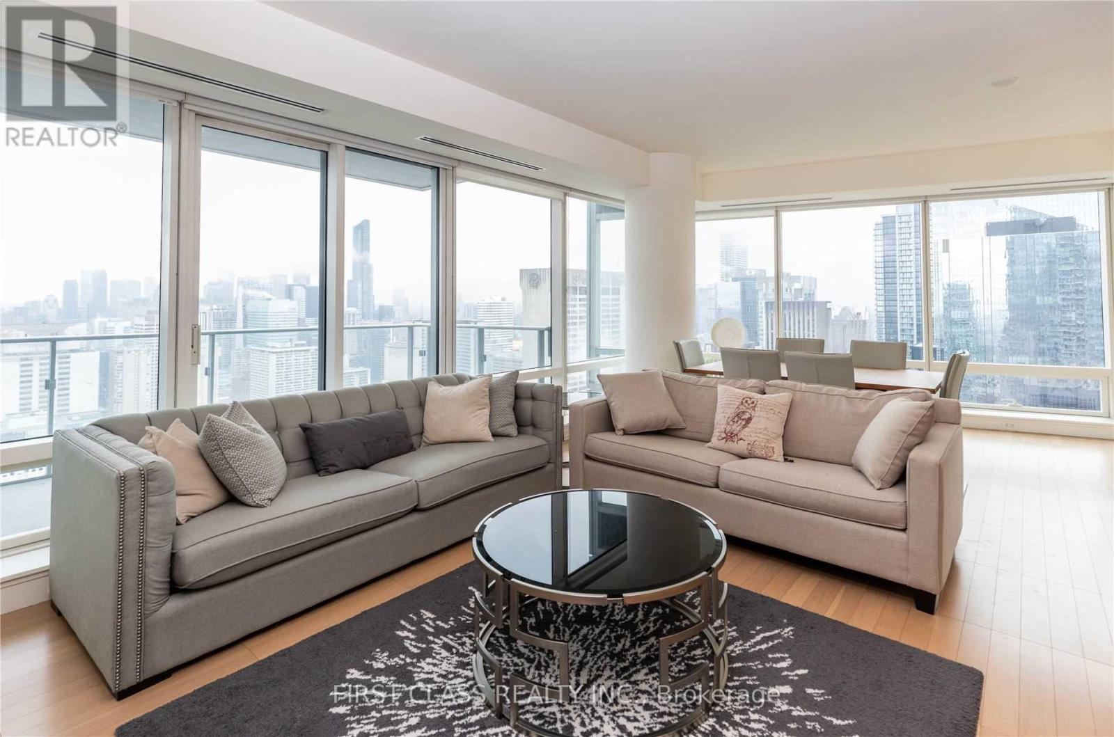 A living room with a grey sofa and a coffee table in front of a large window.