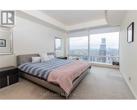A bedroom with a large bed and a view of the city.