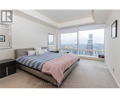 A bedroom with a large bed and a view of the city.