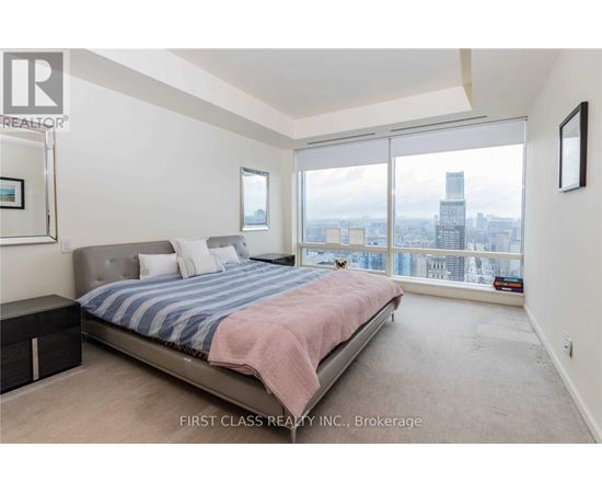 A bedroom with a large bed and a view of the city.