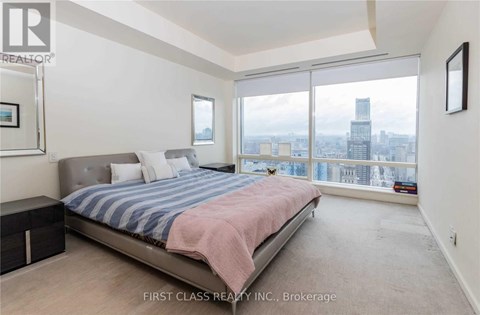 A bedroom with a large bed and a view of the city.