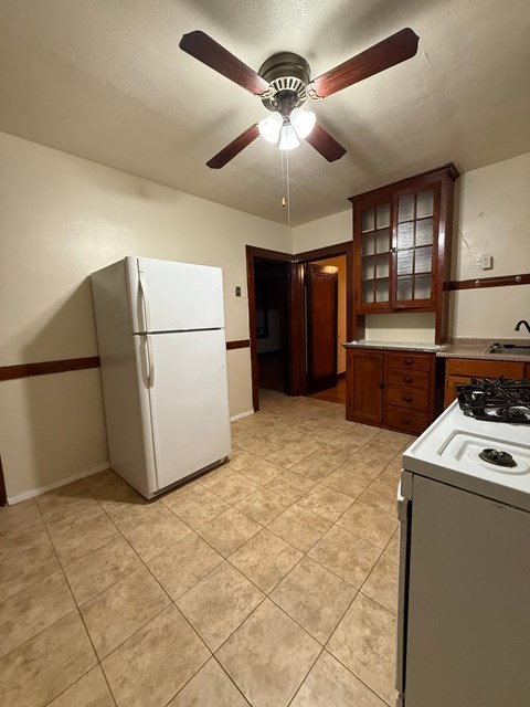 A kitchen with a white refrigerator and a white stove.