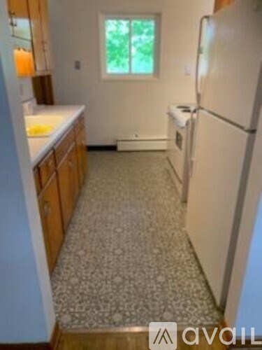 A kitchen with a white fridge and a window.