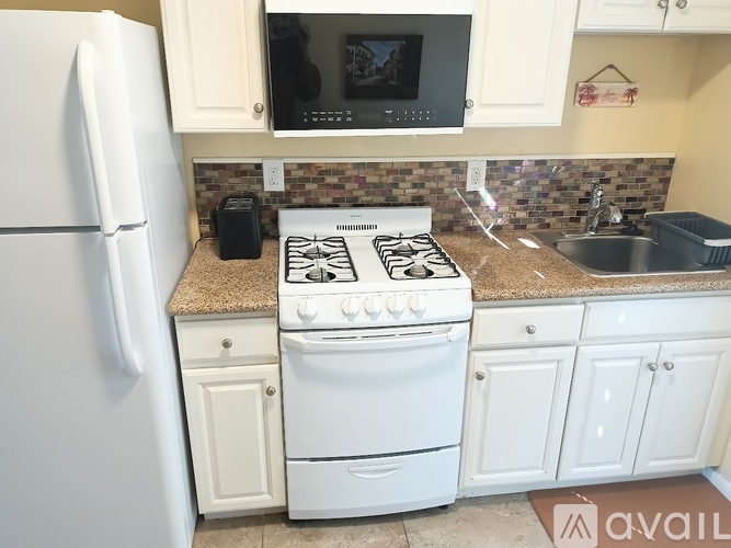 A white stove and refrigerator in a kitchen.