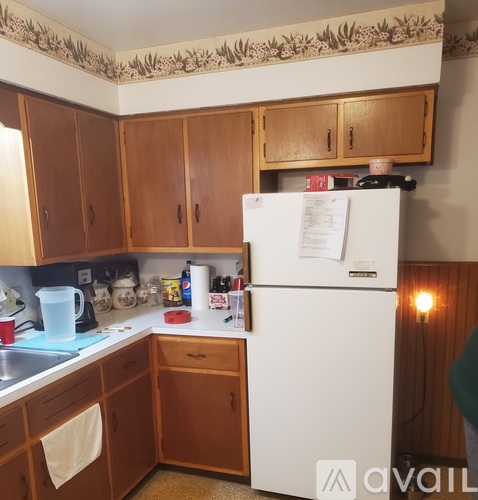 A kitchen with wooden cabinets and a white fridge.