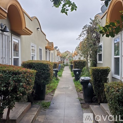 A row of houses with a sidewalk in front.