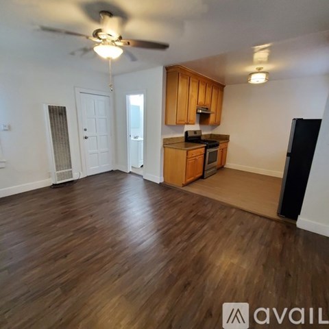 A kitchen with wooden cabinets and a black refrigerator.