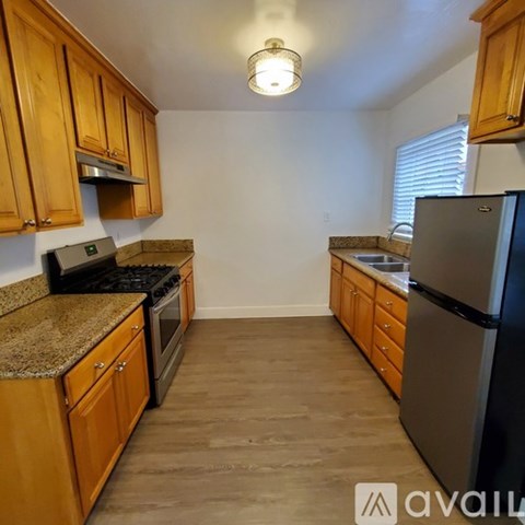 A kitchen with wooden cabinets and a granite countertop.