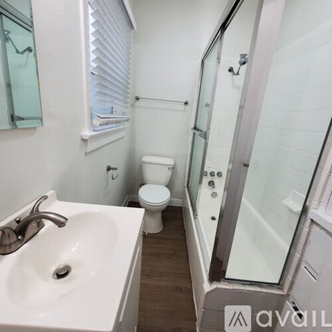 A bathroom with a toilet, sink, and shower.