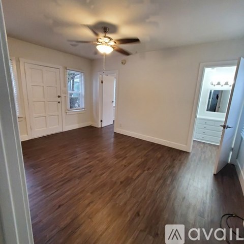 A room with wooden floors and a ceiling fan.