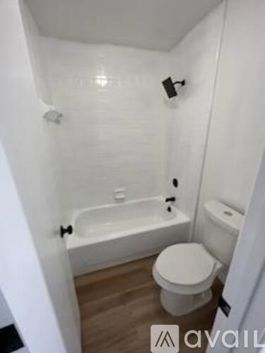 A white bathroom with a toilet, tub, and sink.