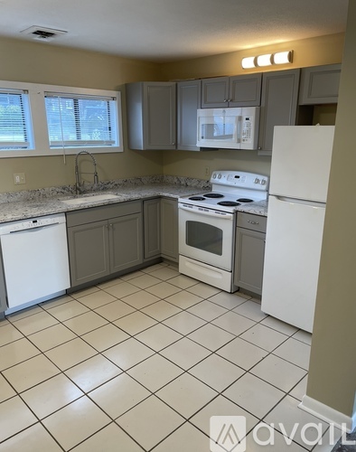 A kitchen with white appliances and a white refrigerator.