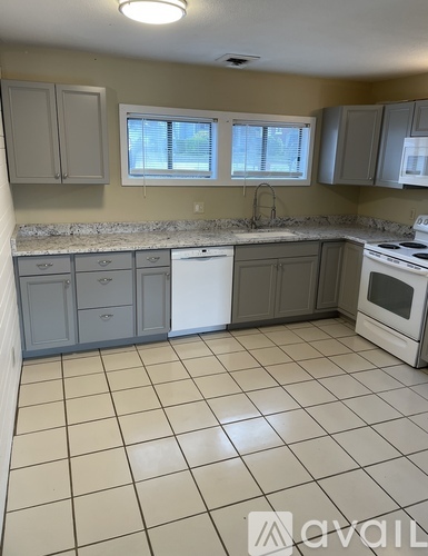A kitchen with white appliances and a white dishwasher.