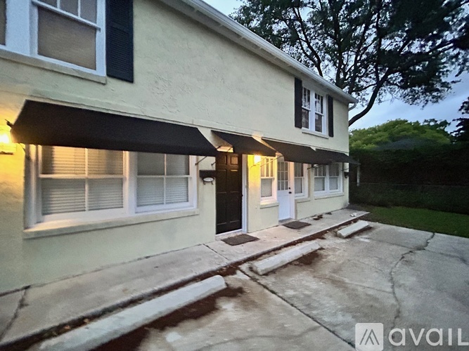A house with a white facade and a black awning.
