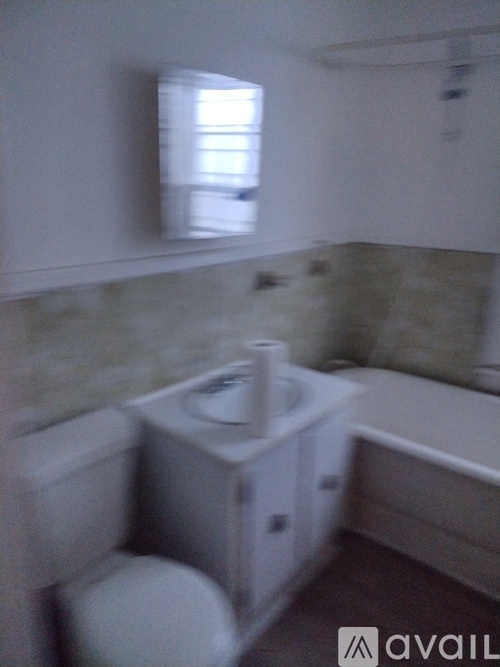 A bathroom with a toilet, sink, and bathtub.